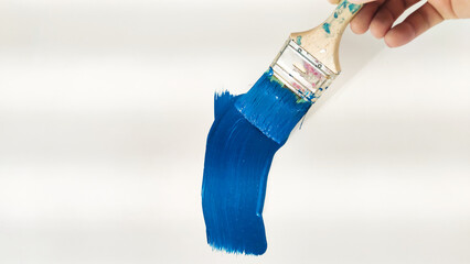 brush with blue paint on a white background