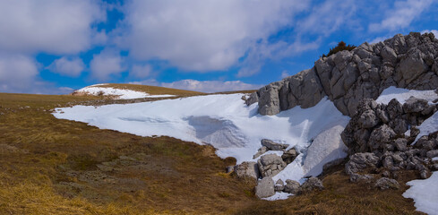 snowbound mountain ridge under a blue cloudy sky