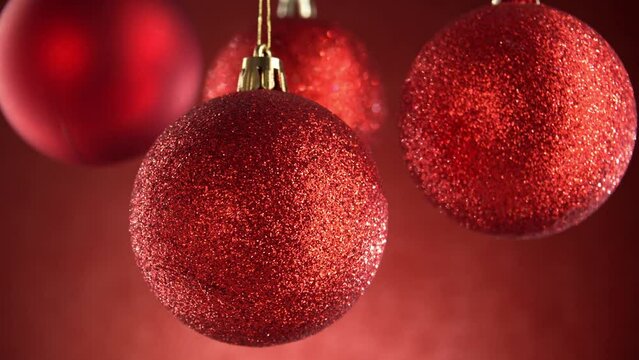 Sparkling Red Christmas Baubles on Red Blurred Background. Close-up, shallow dof.