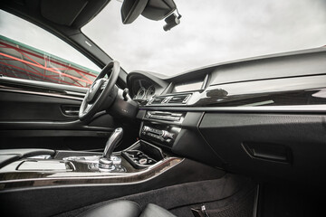 Car inside. Interior of prestige modern car. Comfortable leather seats. Black cockpit with on...