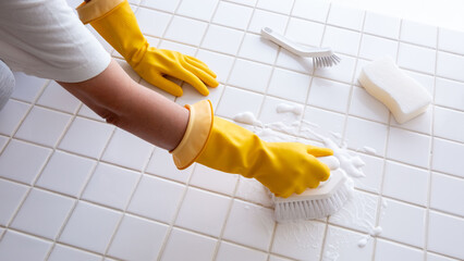 浴室のタイルクリーニング　、ゴム手袋で掃除する主婦の手元