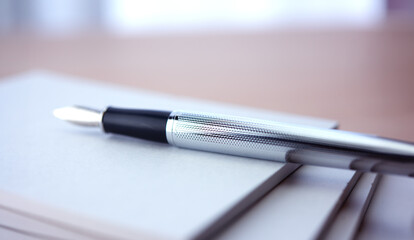 Stylish Silver fountain pen, placed on a blank piece of paper, memo or notepad. Extremely shallow...