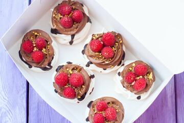Mini cakes with whipped cream, chocolate, meringue and fresh raspberries. Confectionery poster for...