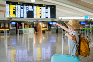 Boy looking departure board in terminal