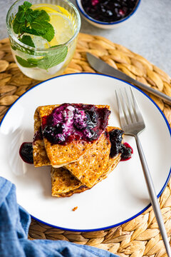 Homemade crepes with blueberry jam and sour cream and lemon water drink