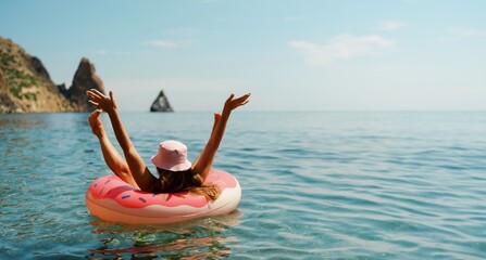 Summer vacation woman in hat floats on an inflatable donut mattress. Happy woman relaxing and enjoying family summer travel holidays travel on the sea.
