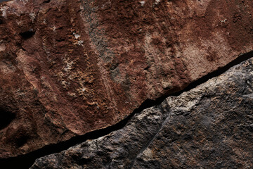 Brown stone texture, dark abstract background. Natural mineral rock close up details, empty backdrop with copy space for design
