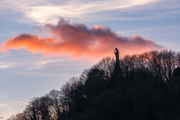 Statue of Jesus at the top of Mount Urgul in San Sebastian, Spain, in the sunset.