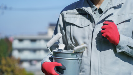 塗装道具を持つ作業服の男性｜リフォーム・塗装業者イメージ
