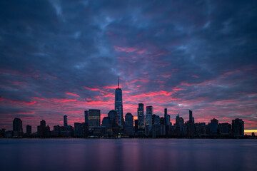 Night atmosphere with red pre-sunrise clouds above Lower Manhattan cityscape. New York panorama as...