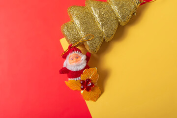 Christmas decoration Santa Claus and golden Christmas tree on red and yellow background