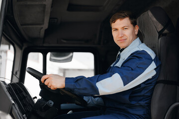 Young man professional driver of mining industrial truck driving