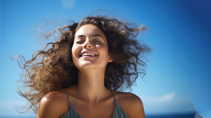 A Brunette woman breathes calmly looking up isolated on clear blue sky