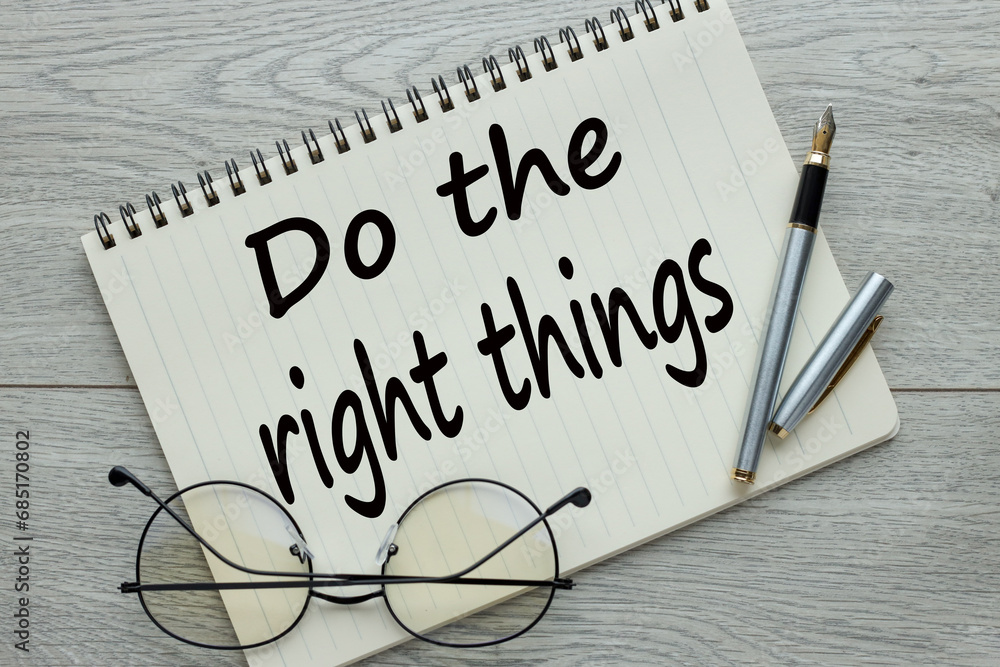 Poster do the right thing. workplace with a notepad and glasses with a pen on a wooden table. text on the p