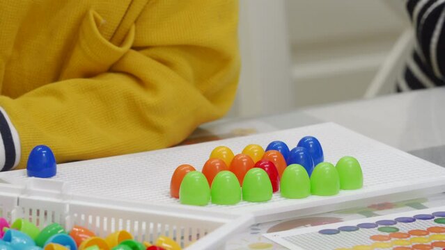 mother and child playing together pegboard mosaic. Early child development. Fine motor skills. Learning and creativity