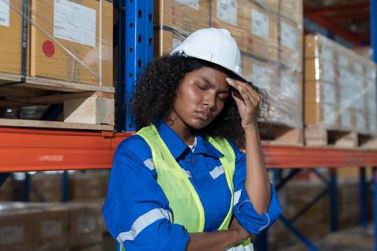Female warehouse worker working with stressed feeling, worry, boring or unhappy in warehouse. Upset woman worker at work. Unhappy black female worker working in storage