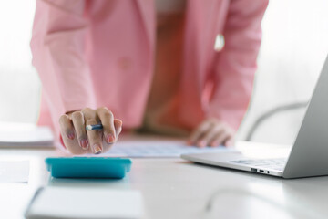 Female office worker working with financial reports for tax audit reports or financial statement in a meeting room. Cropped shot