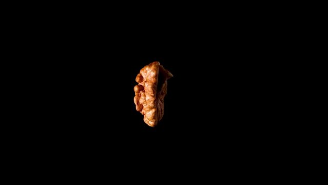 Walnut half isolate rotate 360 isolated on black background slow motion video