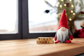 holidays, decoration and celebration concept - close up of merry christmas greeting on wooden toy...
