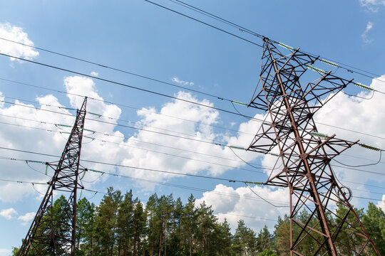 power line and electricity concept - transmission tower over blue sky
