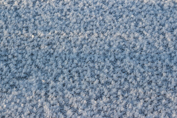 Obraz premium Large crystalline frost on river ice on a frosty day