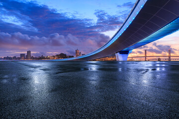 Asphalt road and bridge with city skyline at sunset in Macau