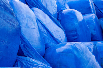 Bottes de pailles emballées dans du plastique bleu