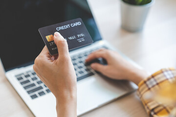 Internet banking, Online shopping at home, asian young woman hand in typing on keyboard, holding credit card, using laptop computer, spending money with purchase on store at home. Shopaholic ecommerce