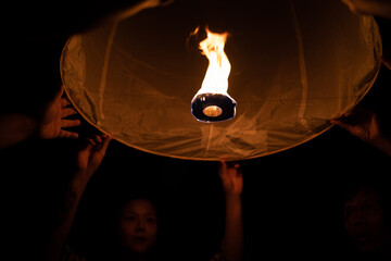 CHIANG MAI, THAILAND - SEPTEMBER 14, 2023: Man and woman holding paper lantern during Yi Peng festival, Chiang Mai, Thailand