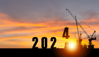 Silhouette of construction with crane and sunset sky for preparation new year of 2024