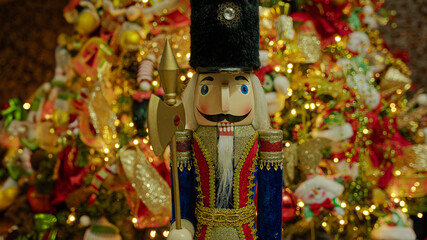 Christmas tree full of decorations with Nutcracker posing.