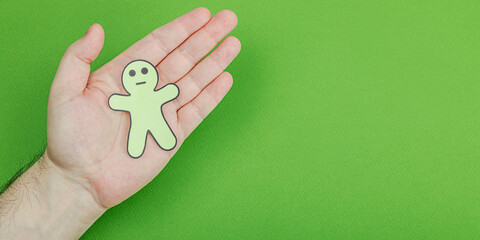 World mental health day. Male hands holding paper men figures with different emotions