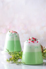 Green matcha Christmas latte with whipped cream and sugar sprinkles, on xmas New year holiday...