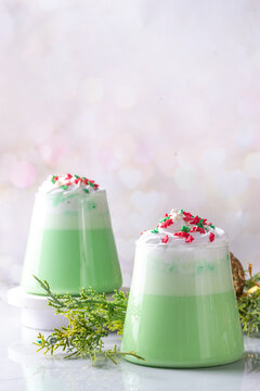 Green matcha Christmas latte with whipped cream and sugar sprinkles, on xmas New year holiday decorated background