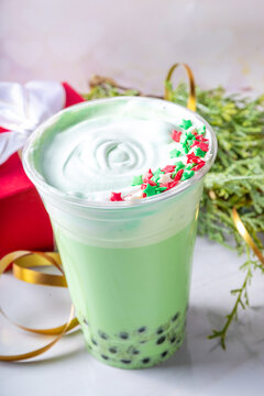 Green Christmas bubble tea drink, cold tasty sweet latte drink with boba balls and Christmas peppermint candy tasty syrup