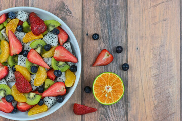 Fresh fruit salad bowl on wood grain table concept healthy food, to control weight, to lose weight
