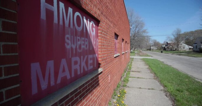 Closed Hmong supermarket boarded up in an urban neighborhood in Detroit.
