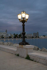 Fototapeta na wymiar Charm Along the Promenade: Beautiful Street Lamps Illuminate Bari, Puglia, Italy