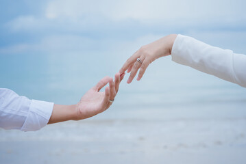 Couple touching hands with wedding rings and sea background, Wedding Poster, invitation card, copy space.