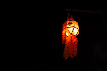 a paper lantern floats on a dark background.