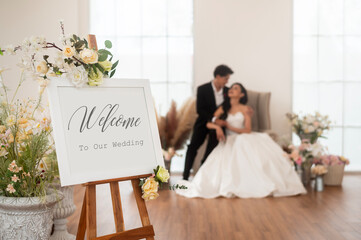 Welcome to wedding sign with bride and groom in background