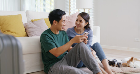 Obraz premium Asia people young family man woman smile happy fun laugh look at phone sit at home pay for hotel booking, search choose, buy ticket on social media app for budget travel abroad trip getaway plan tour.