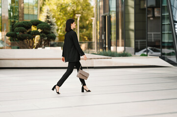 Photo of young woman in casual walking at job near business office center.