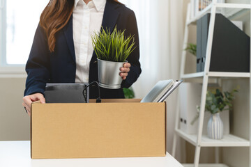 Office worker packing stuff to leave office after resign from job.