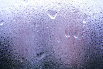 Wet window glass in a cold rainy day as abstract background