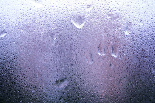Wet window glass in a cold rainy day as abstract background