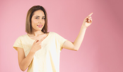 Young beautiful woman over isolated background smiling and pointing with two hands and fingers to the side.