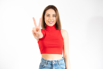 Young pretty woman isolated showing victory sign and smiling broadly.