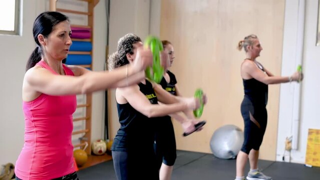 Four women doing trx at the gym, weights training