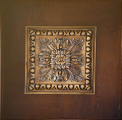 Elegant dark brown ceiling with stone patterns and a rosette texture close up